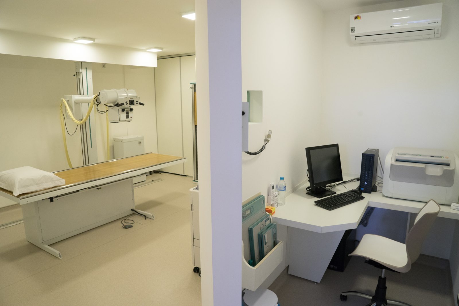 Sala de exames da RioScan, com o aparelho de raio-X digital e a estação de trabalho do técnico